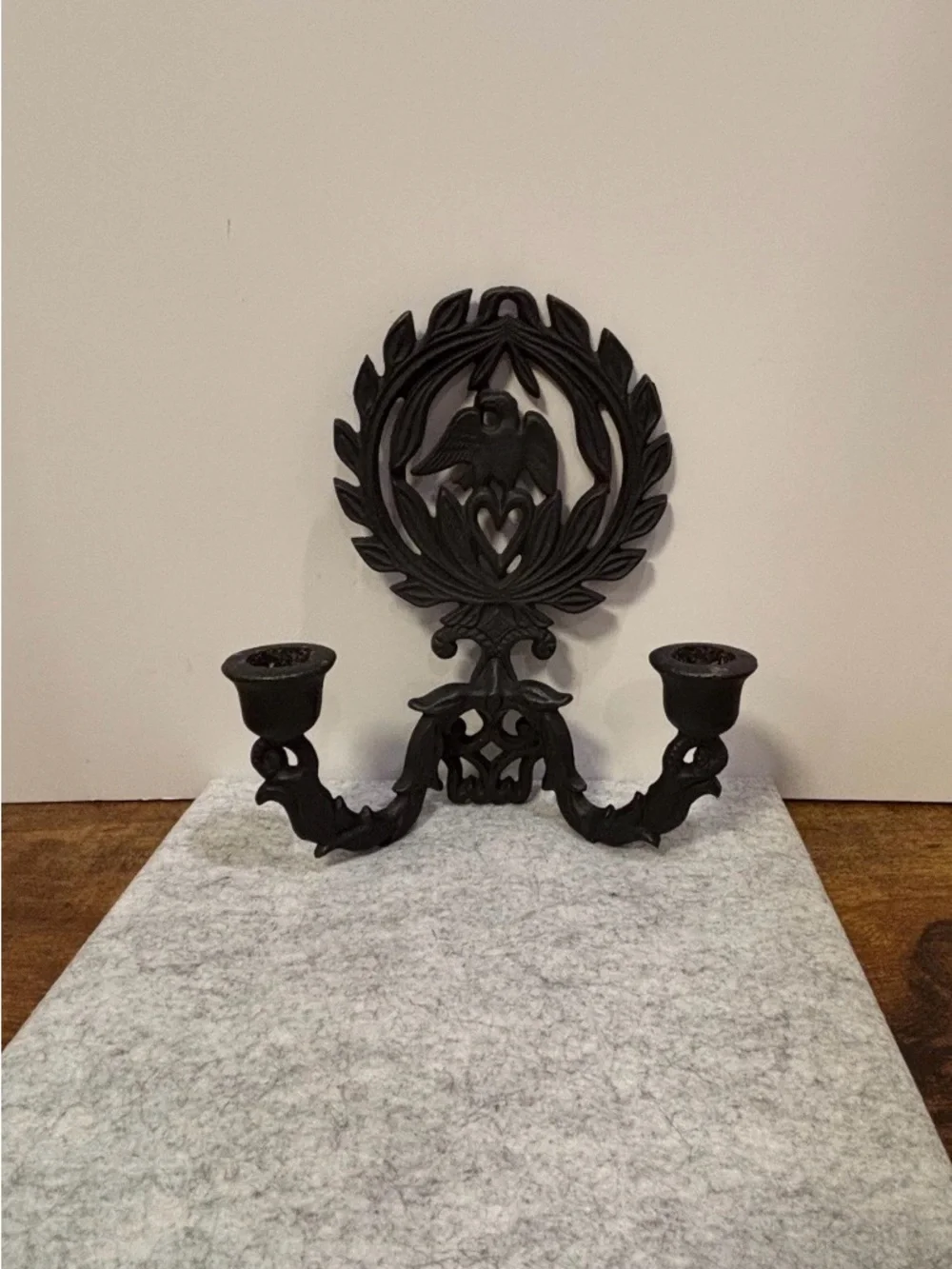A pair of vintage cast iron wall sconces with eagle and laurel wreath motif